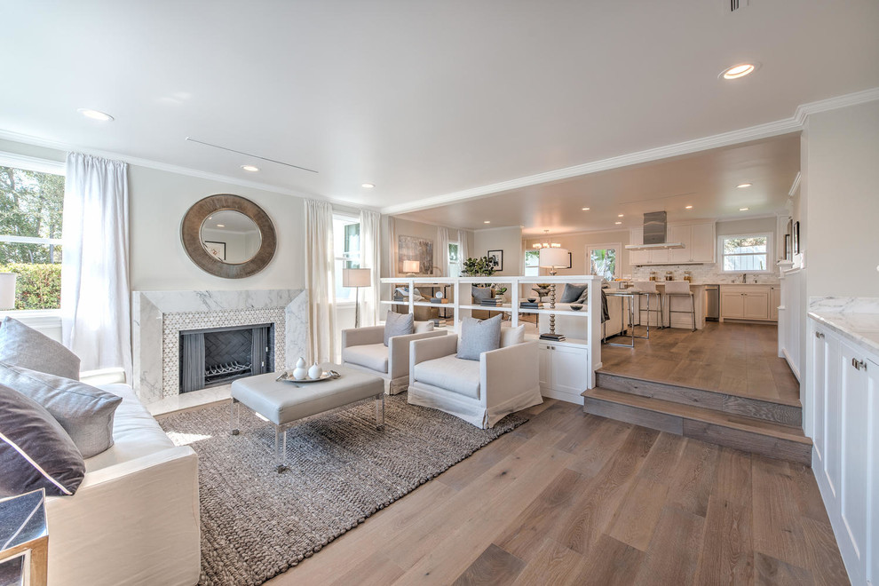 Photo of a small contemporary formal open concept living room in Los Angeles with white walls, medium hardwood floors, a standard fireplace, a stone fireplace surround and no tv.