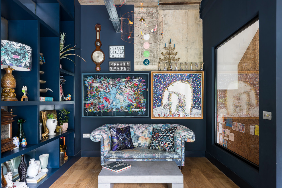 This is an example of an eclectic living room in London with blue walls, medium hardwood floors and brown floor.