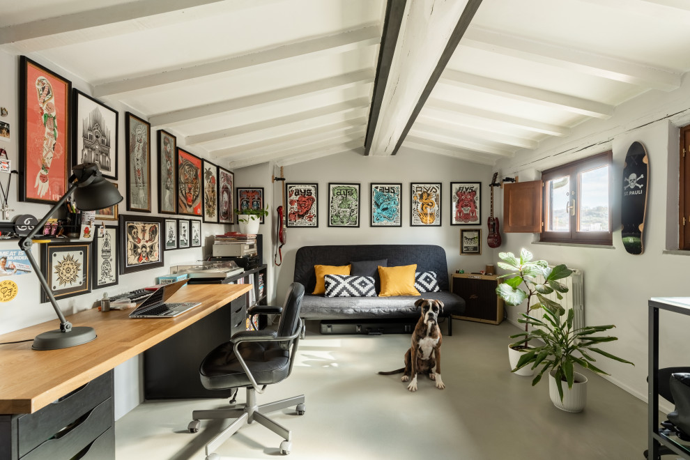 Foto på ett funkis arbetsrum, med vita väggar, betonggolv, ett fristående skrivbord och grått golv