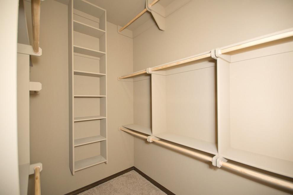 This is an example of a mid-sized traditional gender-neutral walk-in wardrobe in Oklahoma City with open cabinets and carpet.