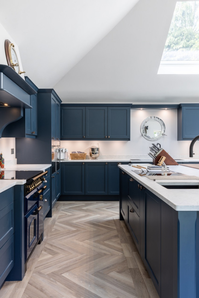 Modelo de cocina actual grande abierta con armarios estilo shaker, puertas de armario azules, encimera de cuarcita, una isla y encimeras blancas