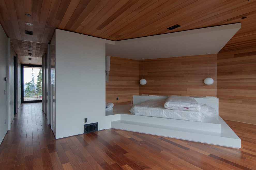 Immagine di una grande camera matrimoniale moderna con pavimento in legno massello medio, soffitto in legno e pareti in legno