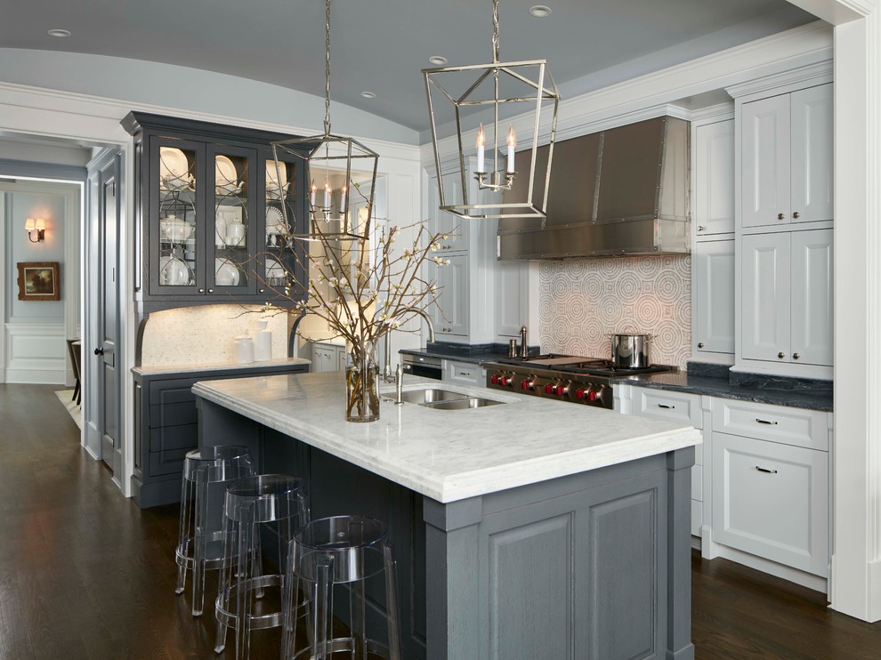 This is an example of a traditional kitchen in Chicago with a double-bowl sink, recessed-panel cabinets, white cabinets, multi-coloured splashback, stainless steel appliances, dark hardwood floors and with island.