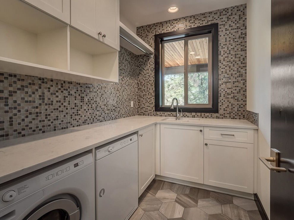 Mid-sized modern l-shaped dedicated laundry room in Portland with an undermount sink, shaker cabinets, white cabinets, quartzite benchtops, grey walls, a side-by-side washer and dryer and grey floor.