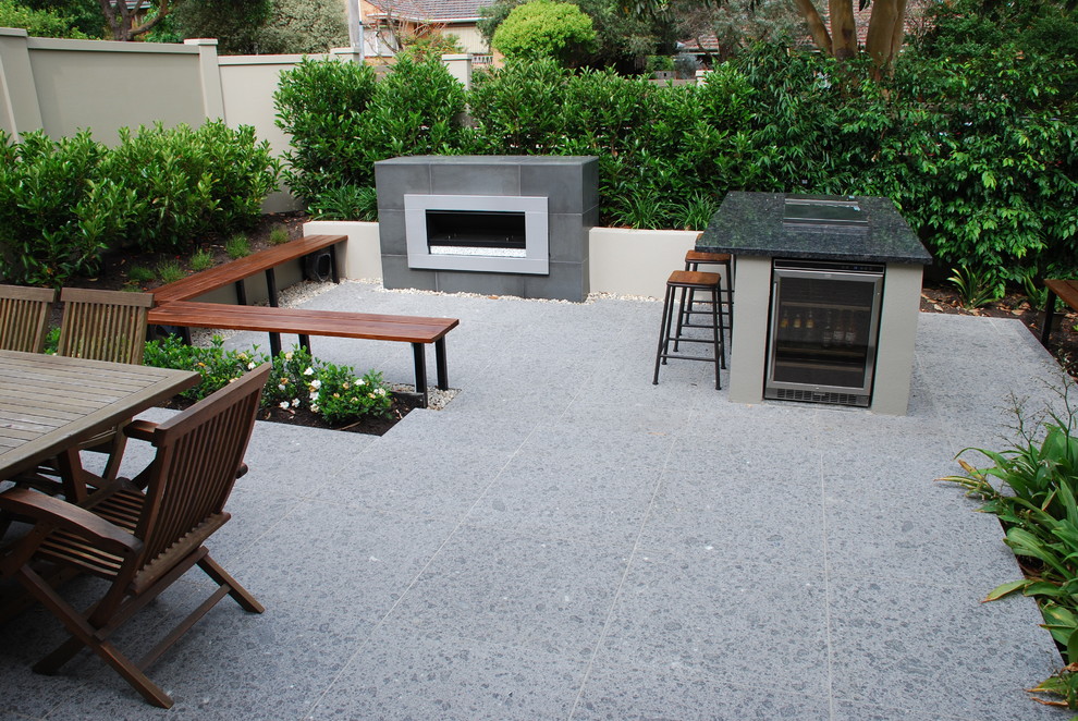 This is an example of a mid-sized contemporary courtyard full sun garden for spring in Melbourne with with privacy feature and natural stone pavers.