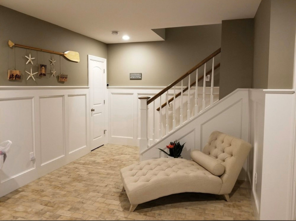 Photo of a transitional fully buried basement with multi-coloured walls, brick floors and beige floor.