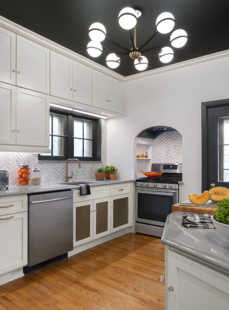Inspiration for a transitional kitchen in St Louis with white cabinets, quartz benchtops, stainless steel appliances, grey benchtop, a single-bowl sink, shaker cabinets, multi-coloured splashback and light hardwood floors.