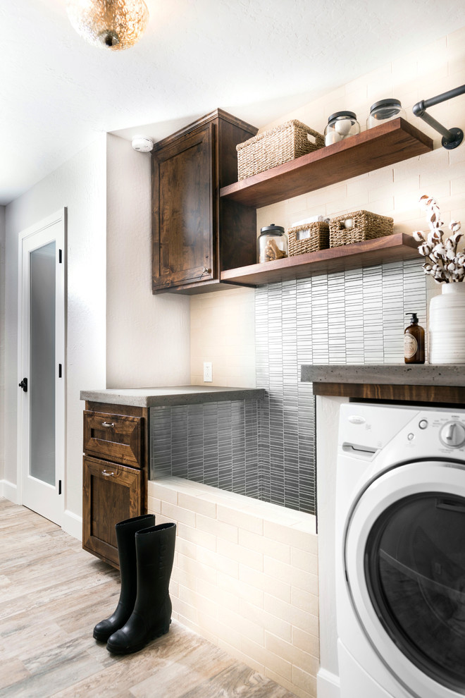 Design ideas for a mid-sized country single-wall dedicated laundry room in Sacramento with a drop-in sink, raised-panel cabinets, dark wood cabinets, concrete benchtops, white walls, medium hardwood floors, a side-by-side washer and dryer, brown floor and grey benchtop.