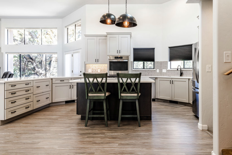 Eat-in kitchen - large transitional u-shaped vinyl floor and gray floor eat-in kitchen idea with an undermount sink, shaker cabinets, gray cabinets, quartzite countertops, green backsplash, subway tile backsplash, stainless steel appliances, an island and white countertops