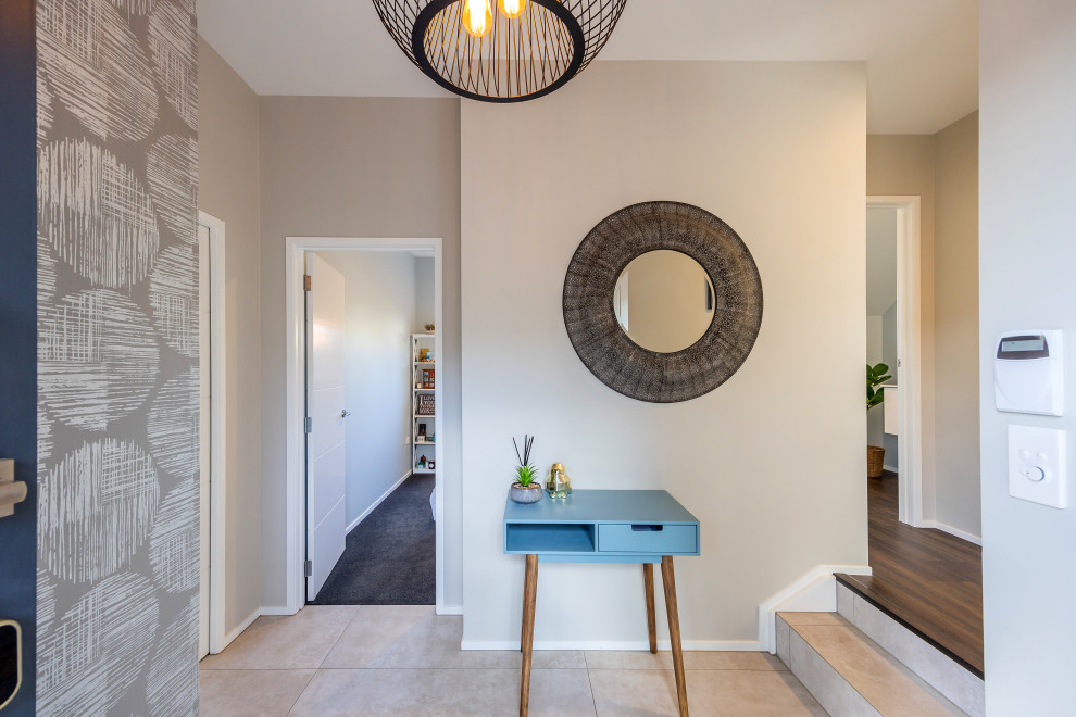オークランドにある低価格の小さなコンテンポラリースタイルのおしゃれな玄関ロビー (白い壁、磁器タイルの床、青いドア、グレーの床) の写真