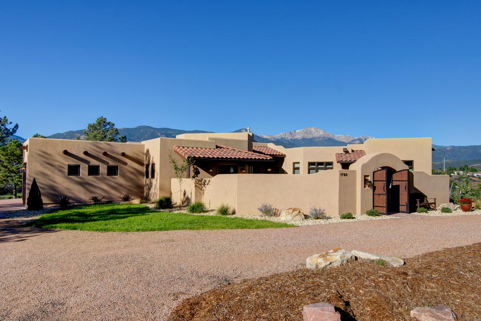 Photo of a large one-storey stucco beige exterior in Denver with a flat roof.