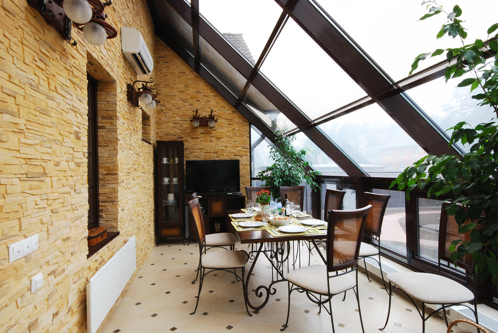 This is an example of a mid-sized mediterranean sunroom in Other.