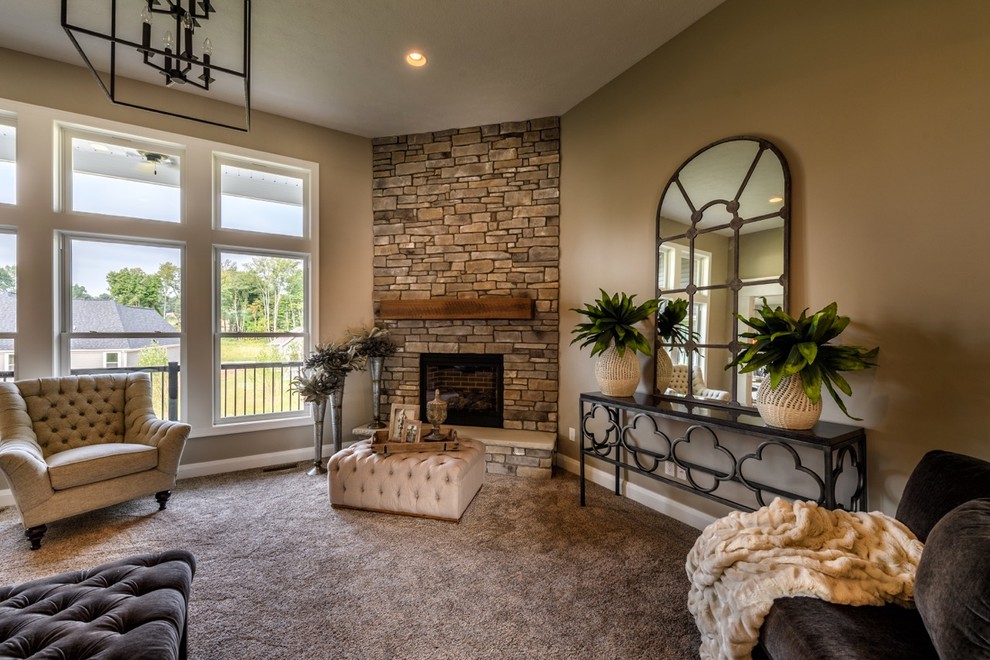 Expansive arts and crafts open concept living room in Cleveland with grey walls, medium hardwood floors, a standard fireplace, a stone fireplace surround and brown floor.