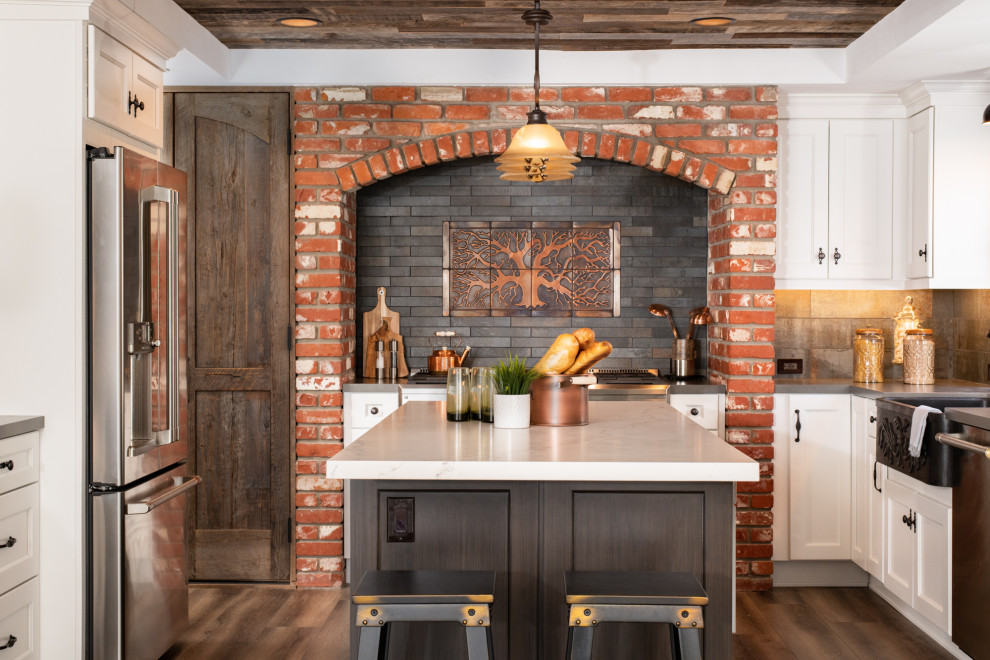 Inspiration for a mid-sized country u-shaped eat-in kitchen in Orange County with quartz benchtops, black splashback, brick splashback, stainless steel appliances, with island and grey benchtop.