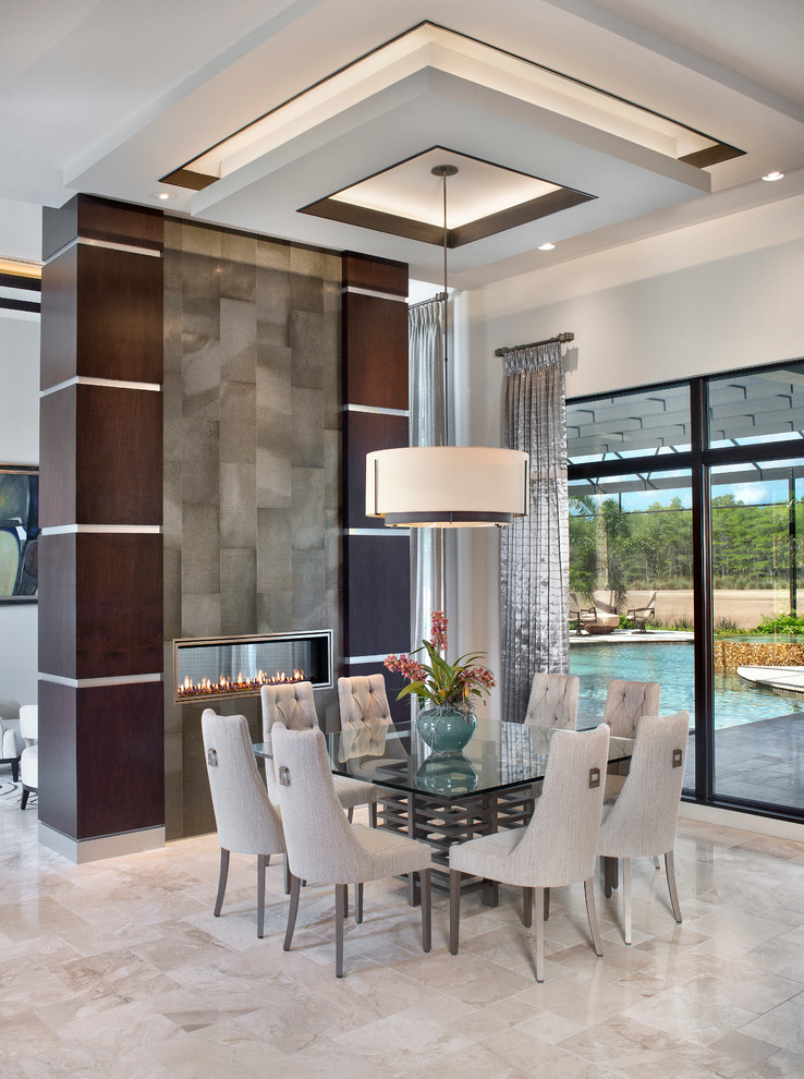 Photo of a contemporary dining room in Miami with a two-sided fireplace and white walls.