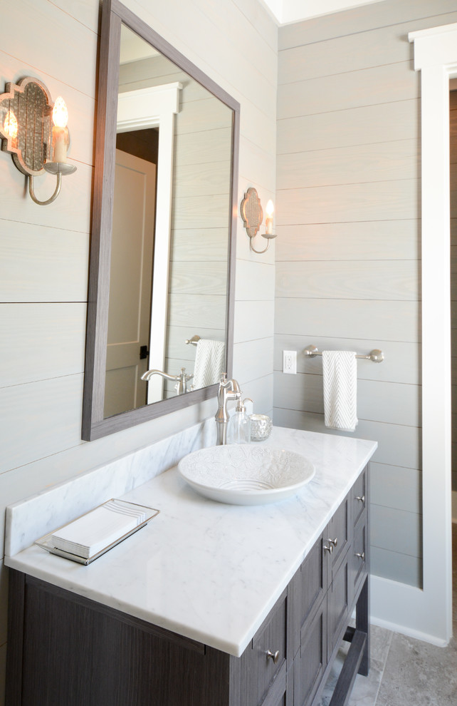 Photo of a mid-sized transitional powder room in Atlanta with furniture-like cabinets, a vessel sink, marble benchtops, grey floor and grey walls.