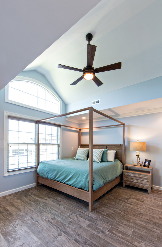 This is an example of a mid-sized beach style master bedroom in Other with blue walls and porcelain floors.