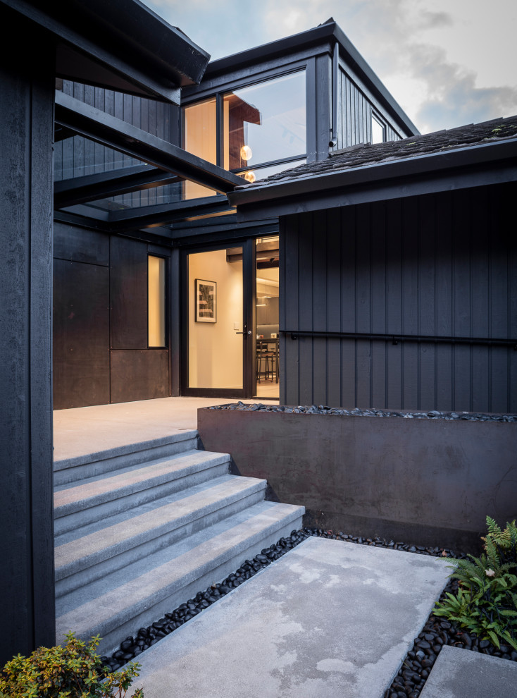 Photo of a contemporary front yard verandah in Seattle with concrete slab and an awning.