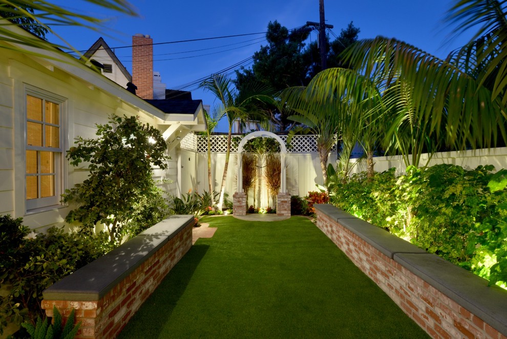 This is an example of a small beach style backyard partial sun xeriscape for spring in San Diego with a retaining wall.