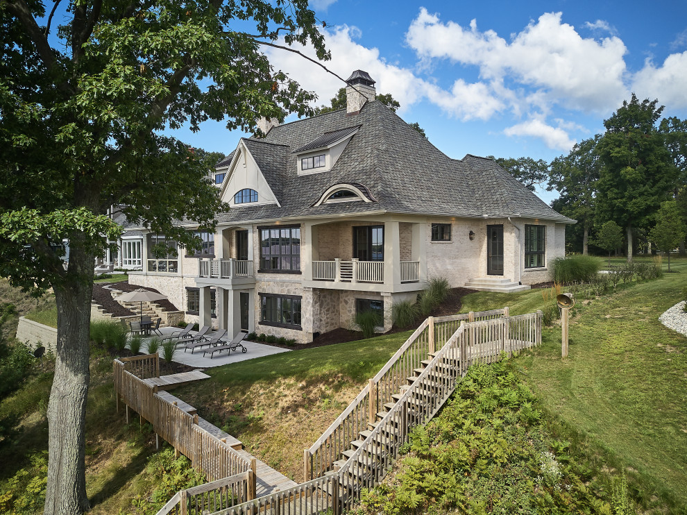 Großes, Einstöckiges Einfamilienhaus mit Mix-Fassade, beiger Fassadenfarbe, Mansardendach, Schindeldach und grauem Dach in Grand Rapids