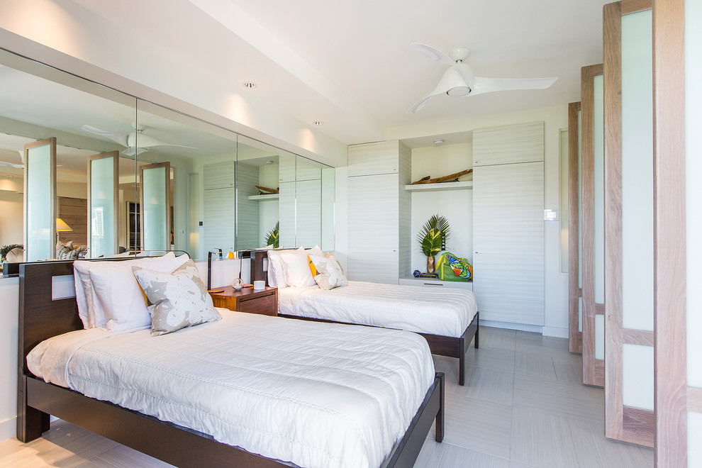 Photo of a tropical bedroom in Hawaii with white walls and light hardwood floors.
