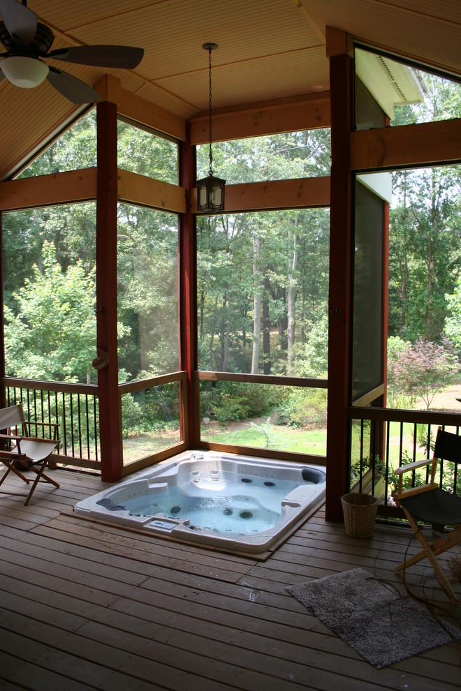 This is an example of a mid-sized rustic screened-in back porch design in Atlanta with a roof extension.