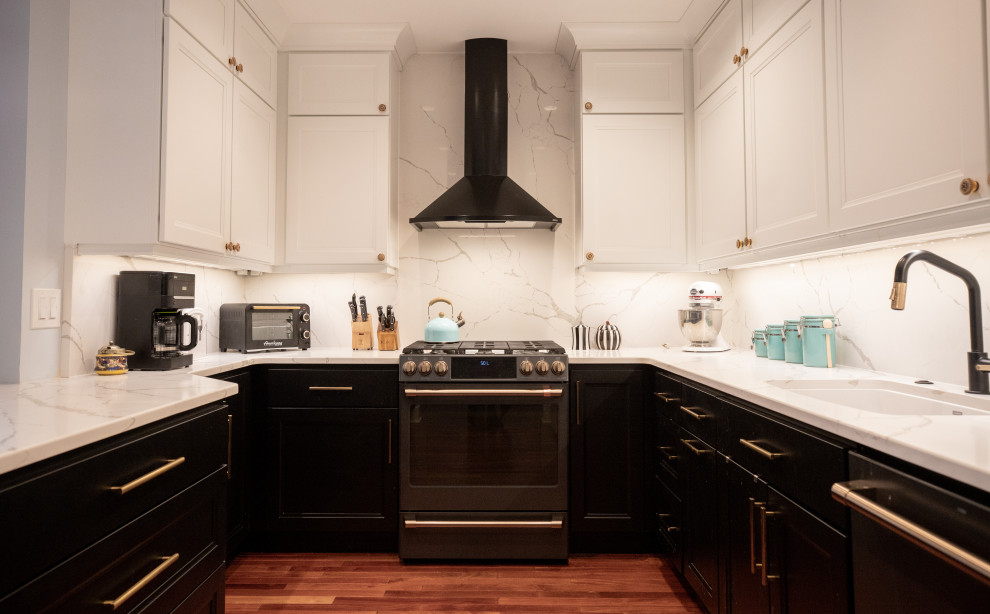 Inspiration for a traditional kitchen in Philadelphia with a single-bowl sink, black cabinets, engineered stone countertops, white splashback, engineered quartz splashback, black appliances, medium hardwood flooring and white worktops.