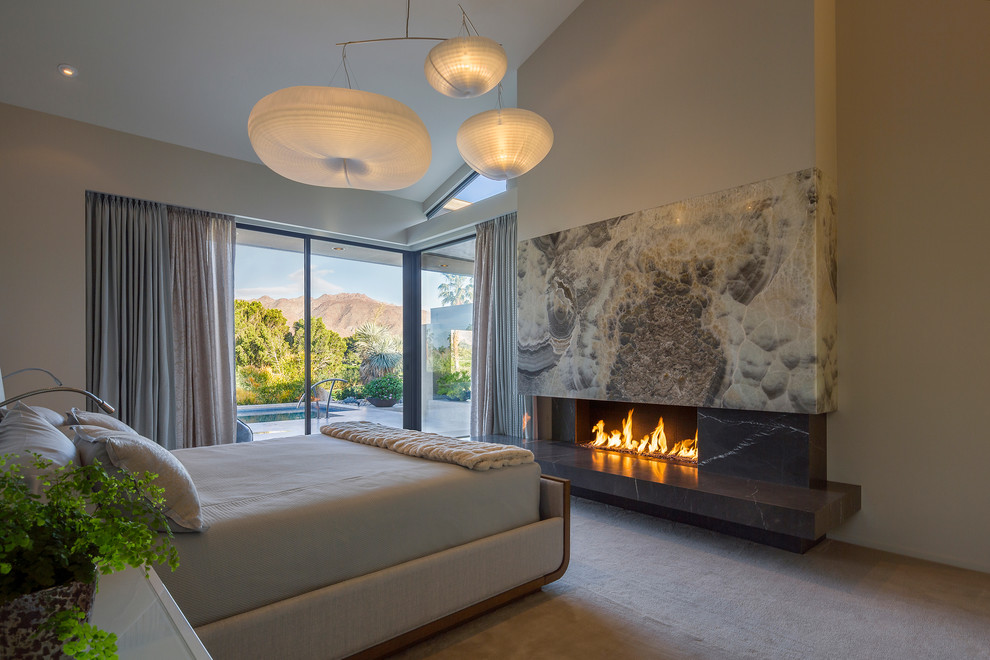 Inspiration for a large contemporary master bedroom in DC Metro with beige walls, carpet, a ribbon fireplace, a stone fireplace surround and beige floor.