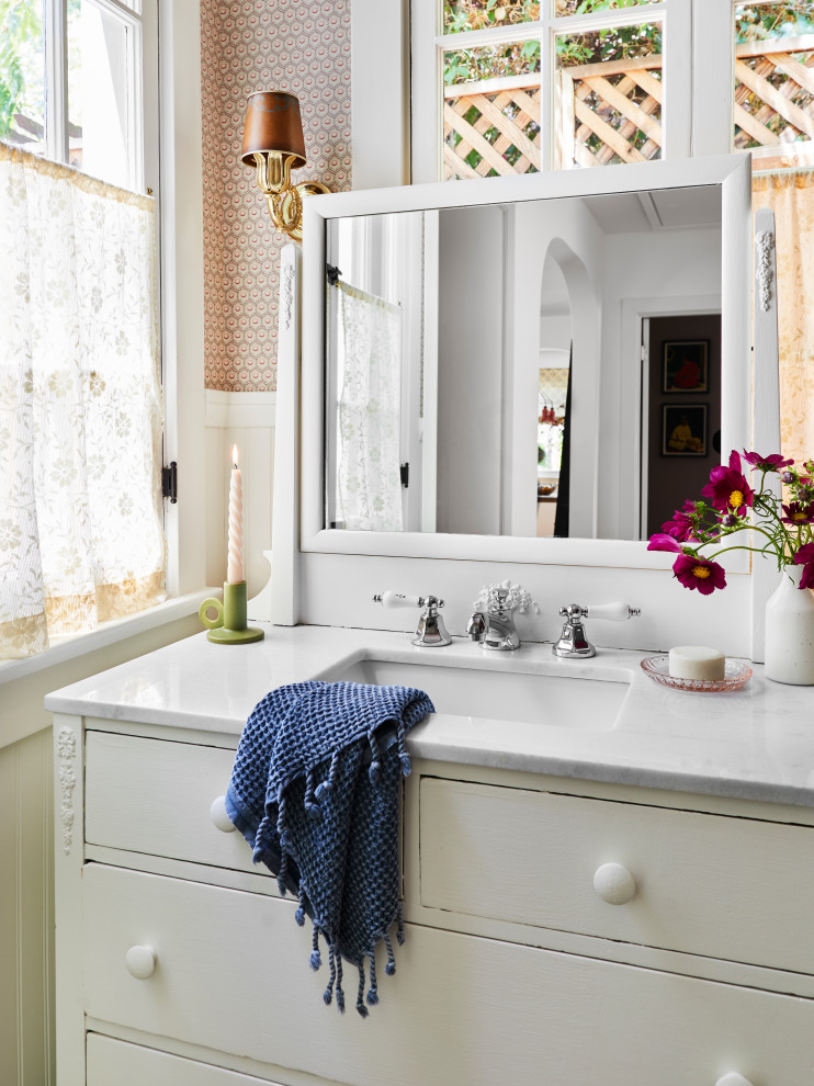Foto di una stanza da bagno bohémian di medie dimensioni con top in marmo, un lavabo e pannellatura