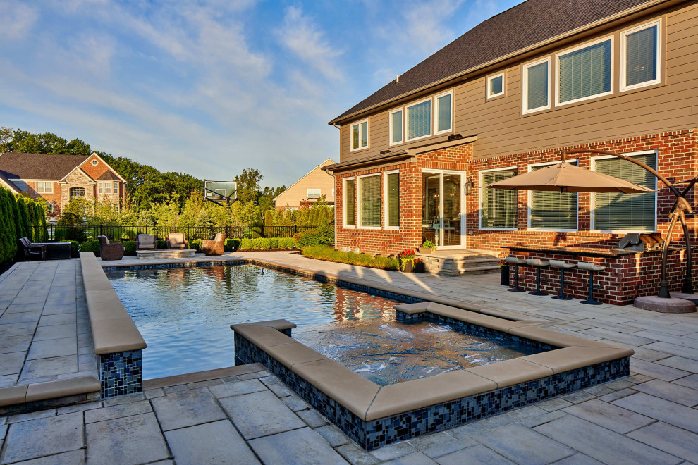 Стильный дизайн: большой прямоугольный бассейн на заднем дворе в современном стиле с джакузи и мощением тротуарной плиткой - последний тренд