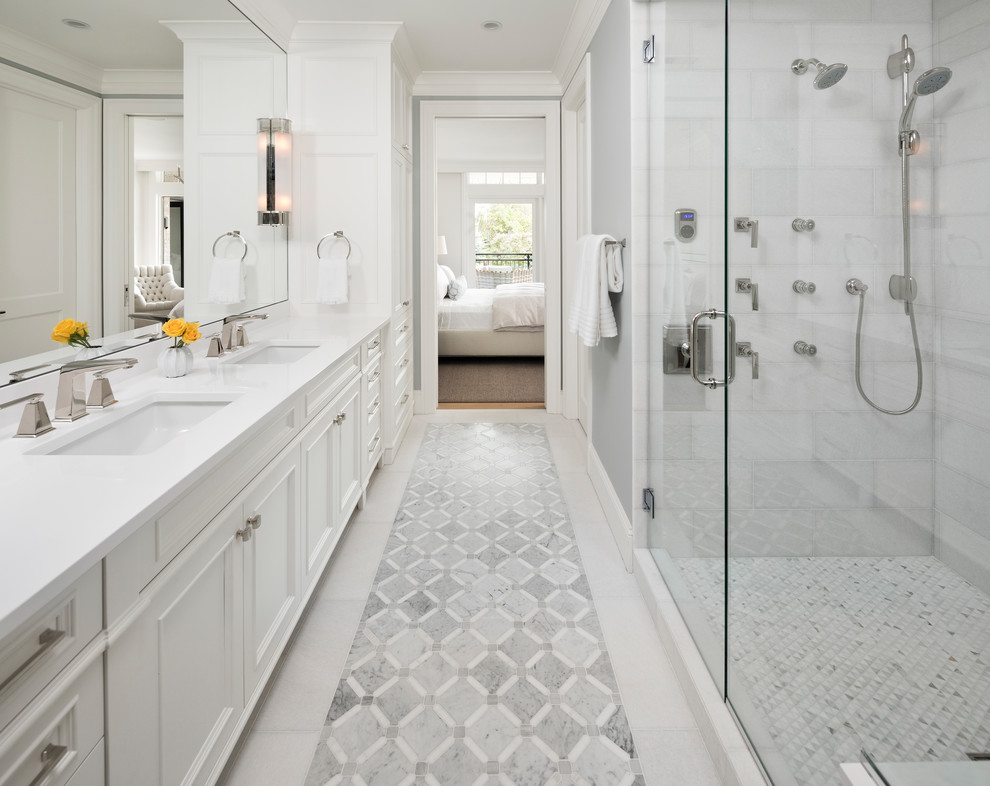 Mid-sized transitional master bathroom in Minneapolis with white cabinets, grey walls, marble floors, engineered quartz benchtops, white floor, a hinged shower door, recessed-panel cabinets, a double shower, an undermount sink and white benchtops.