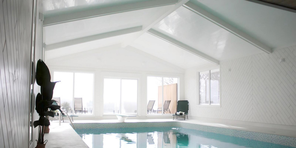 Idee per una grande piscina coperta fuori terra scandinava rettangolare con una dépendance a bordo piscina e cemento stampato