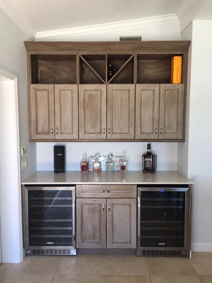 Inspiration for a mid-sized traditional single-wall wet bar in Tampa with raised-panel cabinets, light wood cabinets, quartz benchtops, ceramic floors, brown floor and beige benchtop.