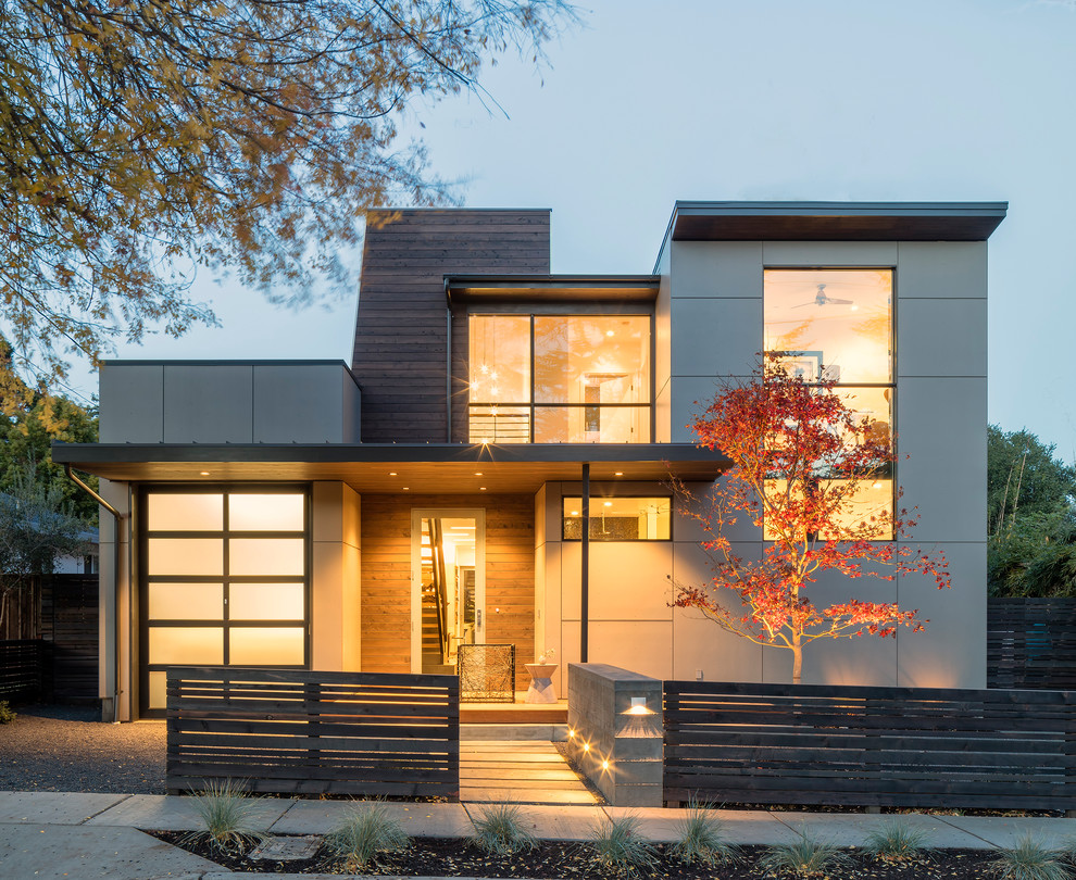 Contemporary split-level grey exterior in Other with mixed siding and a flat roof.