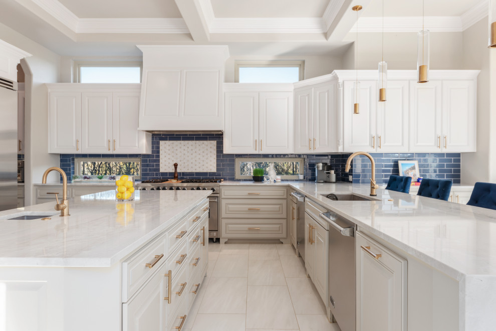 Expansive transitional u-shaped open plan kitchen in Dallas with a single-bowl sink, raised-panel cabinets, white cabinets, quartzite benchtops, blue splashback, glass tile splashback, stainless steel appliances, porcelain floors, with island, white floor, white benchtop and coffered.
