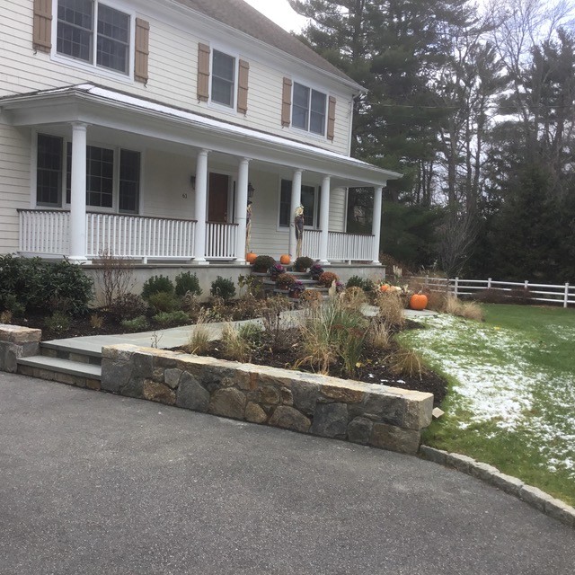 Inspiration for a mid-sized traditional front yard full sun driveway for winter in New York with natural stone pavers.