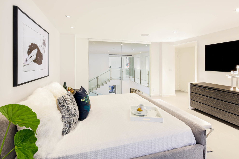 Photo of a large modern master bedroom in Miami with white walls and porcelain floors.