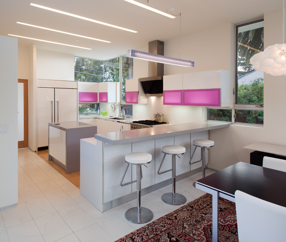 Photo of a contemporary u-shaped eat-in kitchen in San Diego with flat-panel cabinets, white splashback, panelled appliances and a peninsula.