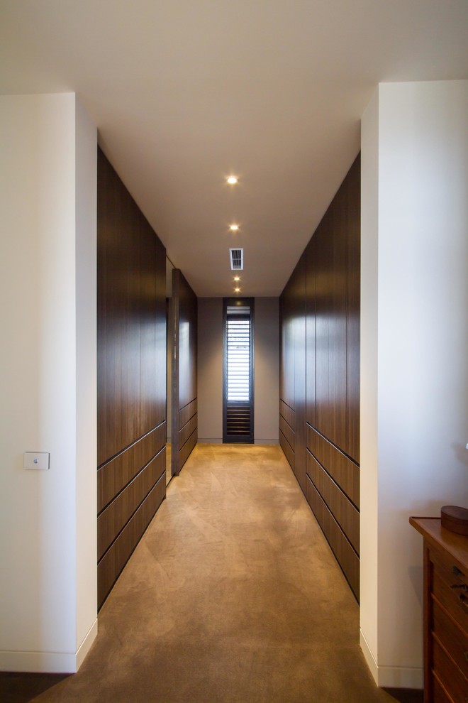 Design ideas for a large contemporary gender-neutral walk-in wardrobe in Melbourne with flat-panel cabinets and carpet.