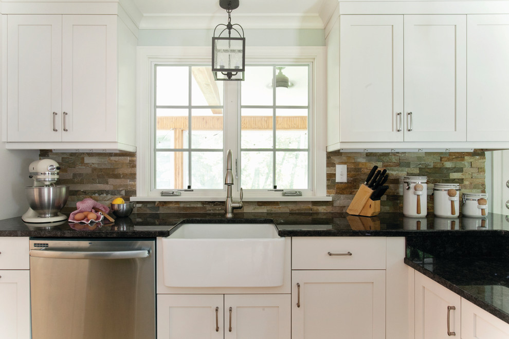 This is an example of a traditional kitchen in Raleigh with a farmhouse sink, white cabinets and slate splashback.