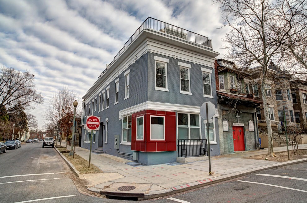 Mid-sized contemporary two-storey brick blue exterior in DC Metro with a flat roof.