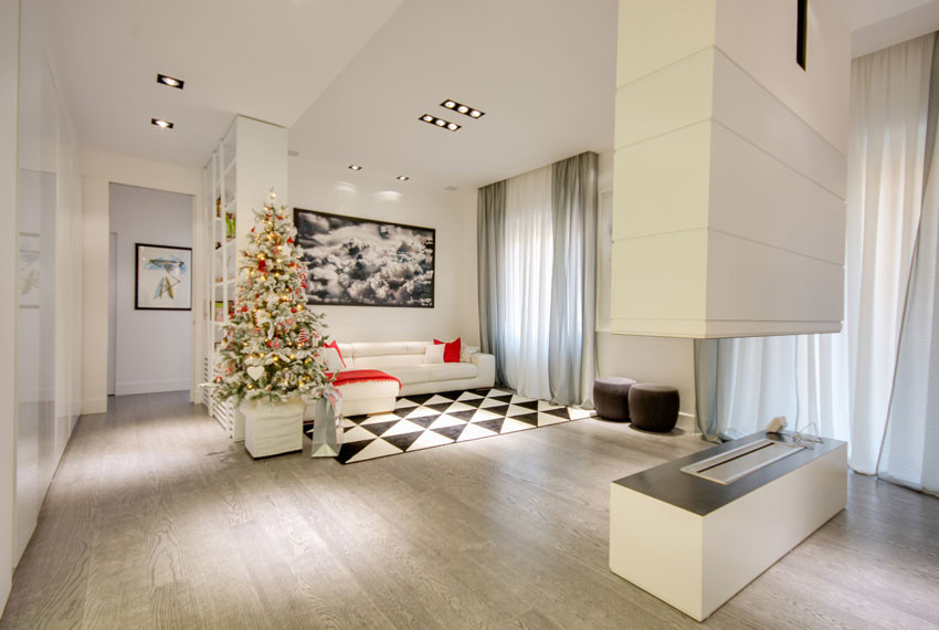 Design ideas for an expansive modern open concept living room in Rome with a library, white walls, light hardwood floors, a hanging fireplace, a plaster fireplace surround, a concealed tv, beige floor and recessed.