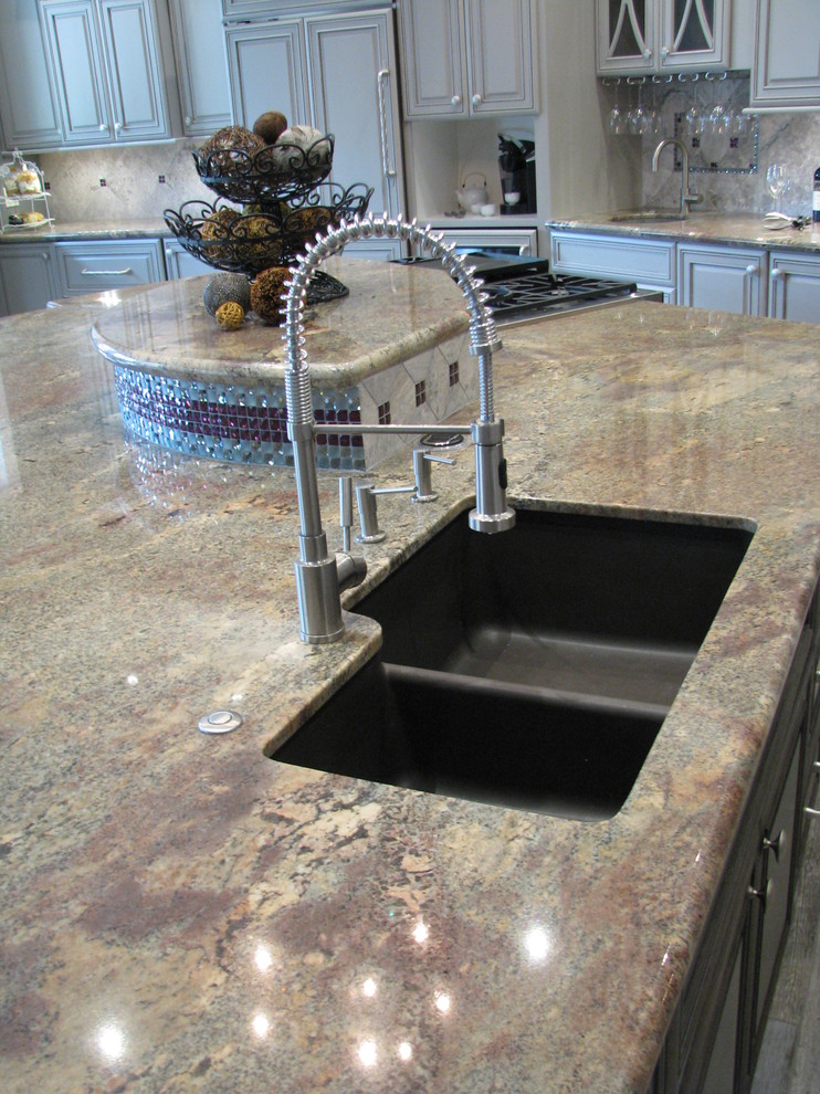 Open concept kitchen - huge transitional l-shaped porcelain tile open concept kitchen idea in Phoenix with an undermount sink, raised-panel cabinets, gray cabinets, granite countertops, gray backsplash, stone tile backsplash, stainless steel appliances and an island