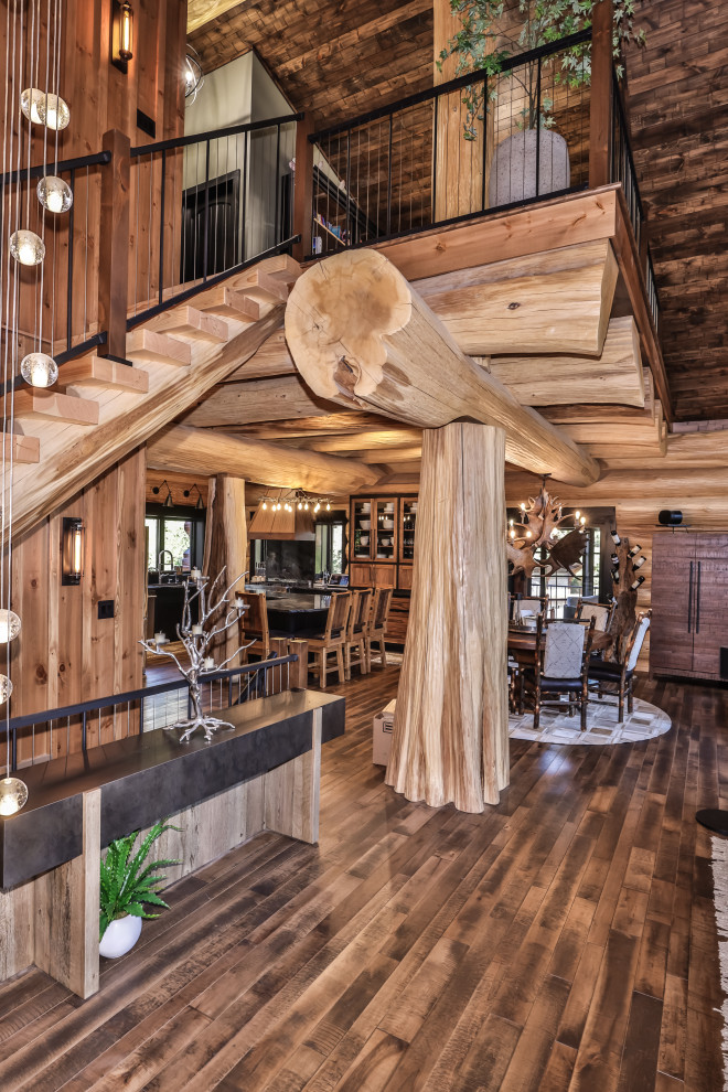 Inspiration for a rustic u-shaped dark wood floor, brown floor and exposed beam open concept kitchen remodel with an undermount sink, shaker cabinets, black cabinets, solid surface countertops, multicolored backsplash, stainless steel appliances, an island and multicolored countertops