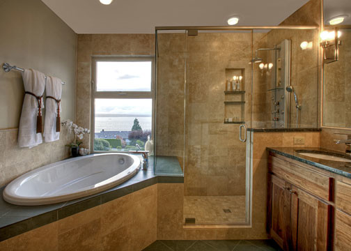 Photo of a large transitional master bathroom in Seattle with an undermount sink, shaker cabinets, medium wood cabinets, granite benchtops, a drop-in tub, an alcove shower, beige tile, brown walls, slate floors, travertine, green floor, a hinged shower door, green benchtops, a niche, a double vanity and a built-in vanity.