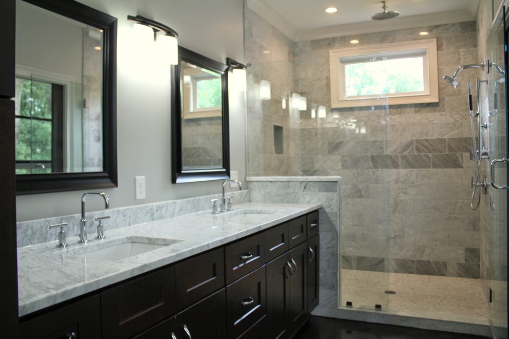 Design ideas for a mid-sized contemporary master bathroom in Atlanta with shaker cabinets, dark wood cabinets, an alcove shower, gray tile, marble, grey walls, dark hardwood floors, an undermount sink, marble benchtops, brown floor, a hinged shower door and grey benchtops.