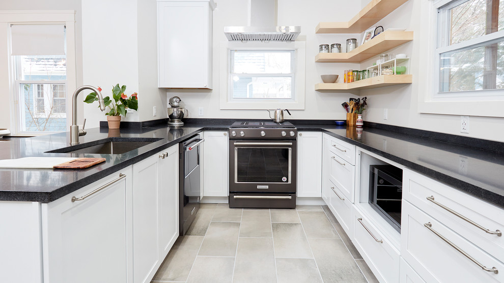 Inspiration for a mid-sized transitional u-shaped eat-in kitchen in Baltimore with an undermount sink, shaker cabinets, white cabinets, granite benchtops, white splashback, window splashback, stainless steel appliances, ceramic floors, a peninsula, grey floor and black benchtop.