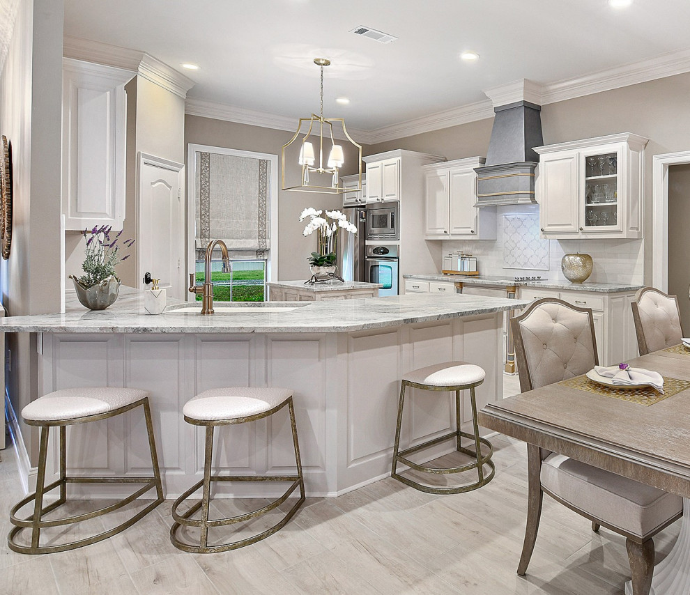 Eat-in kitchen - mid-sized transitional u-shaped porcelain tile and gray floor eat-in kitchen idea with raised-panel cabinets, white cabinets, granite countertops, white backsplash, marble backsplash, an island, multicolored countertops, an undermount sink and stainless steel appliances