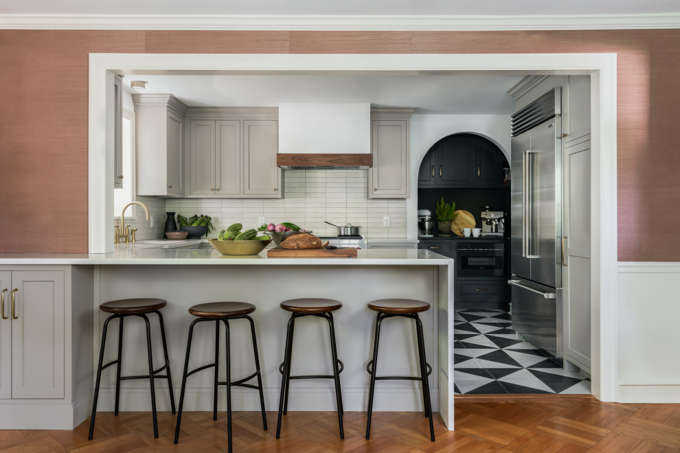 Inspiration for a mid-sized timeless u-shaped cement tile floor and multicolored floor eat-in kitchen remodel in Philadelphia with an undermount sink, shaker cabinets, gray cabinets, quartz countertops, beige backsplash, ceramic backsplash, stainless steel appliances, a peninsula and white countertops