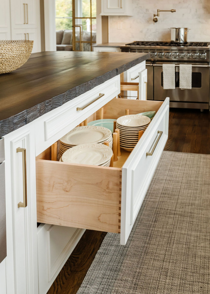 Inspiration for a coastal medium tone wood floor kitchen remodel with white cabinets and an island